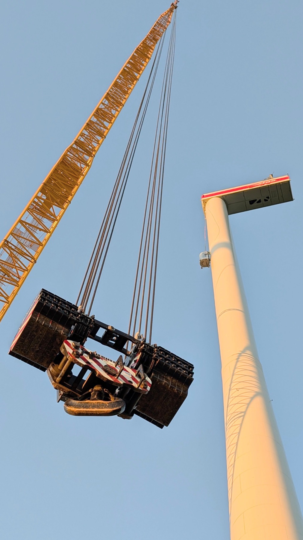 Heavy crane equipment beside a wind turbine, illustrative stock photograph