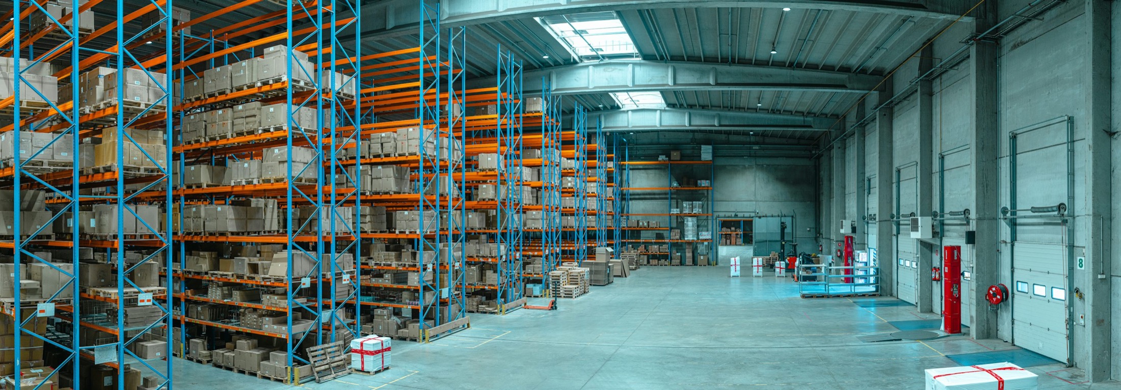Large pallet warehouse with storage racks and loading area, illustrative stock photograph